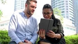 Smiling business couple sharing digital tablet Stock Footage