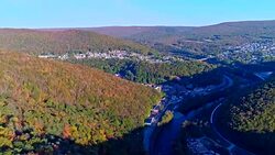 The top view on the road in the mountain's forest in Appalachian, Poconos, Pennsylvania, with fall foliage. Aerial drone video. Stock Footage