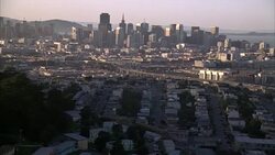 AERIAL OF DOWNTOWN SAN FRANCISCO SKYLINE. SEE CARS DRIVING ON INTERSTATE FREEWAY TOWARDS DOWNTOWN BUILDINGS. SEE HARBOR OR OCEAN BEHIND SKYSCRAPERS. Stock Footage