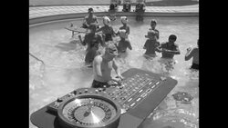 People in the Las Vegas Nevada Sands Hotel swimming pool playing roulette and blackjack in the 1950s News Clip