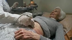 Positive Senior Lady Getting Ultrasound Exam of Stomach Stock Footage