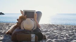 Woman traveler is holding touch pad, while is relaxing outdoors during his trip on the sea. Stock Footage