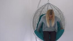 Beautiful girl thumbs a magazine in the chair Stock Footage