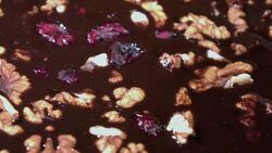 Rotating nuts and cranberry in chocolate in 4K Stock Footage