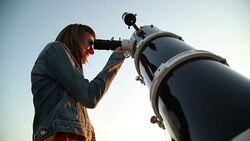 Young woman looking at the sky with astronomical telescope. Stock Footage