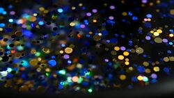 Defocused shimmering multicolored glitter confetti, black background. Party, magic, imagination. Rainbow colors, sparkle circles. Holiday abstract festive texture of shiny blurred bokeh light spots. Stock Footage