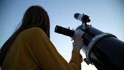 Young woman looking at the sky with astronomical telescope. Stock Footage