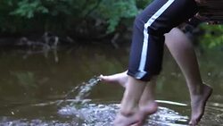 Teens relaxes by the river sitting on the edge of a wooden jetty. Stock Footage