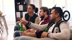 Focused men watching footaball match in living room Stock Footage