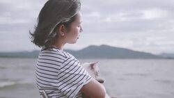 Young woman playing with her cat by the lake. Stock Footage