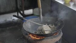 Slow motion shot of a man cooking with charcoal stove. Noodle dish in wok made on open fire. Street food in Chinatown of Bangkok, Thailand Stock Footage