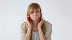 beautiful long-haired girl of European appearance with blond hair looks at her face closeup Stock Footage