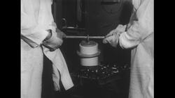 United States, 1950s: Scientists pick up metal canister Stock Footage