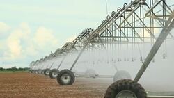Pivot irrigation system in 4K 60fps. Close-up of pivot sprinkler system irrigating crops. Irrigation pivot system watering agriculture field Stock Footage
