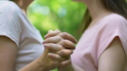 Pretty lesbians holding hands and kissing each other with love outdoors, closeup Stock Footage