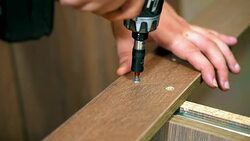 Fastening the panel with a screw using a screwdriver. Hand screwdriver in a vertical position. furniture Stock Footage
