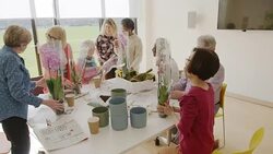 Active seniors learning to arrange orchid flowers Stock Footage