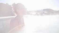 Geothermal spa. Woman relaxing in hot spring pool in Iceland. Girl enjoying bathing in a blue water lagoon Icelandic tourist attraction. 4K Stock Footage