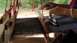 Traditional textile manufacture in craft village where old women work on wooden weaving loom machines and spin yarn creating silk or cotton fabric. Silk weaving in Thailand. Stock Footage
