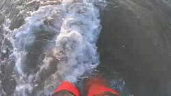 Feet with wave on sandy beach top view slow motion Stock Footage