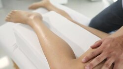 Male physiotherapist giving leg massage to female patient Stock Footage