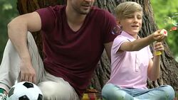 Soap bubbles leisure time together, zoo daddy entertains child in summer park Stock Footage