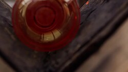 Orange glass is rolled against sheets of soaked newspaper in a glassblowing workshop. Stock Footage