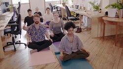 Serene creative business people meditating in office Stock Footage