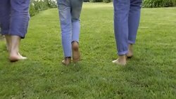 Daughter holding hands with parents and walking on lawn Stock Footage