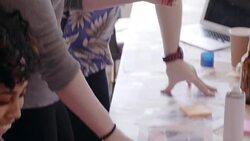 Creative designers reviewing and cutting photograph proofs in office meeting Stock Footage