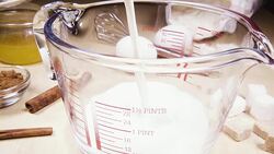 Slow motion glass measuring cup on the table near the ingredients Stock Footage