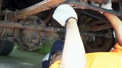 Mechanic laying down and move to under vehicle Stock Footage