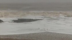 Stormy sea crashing onto snow covered shore News Clip