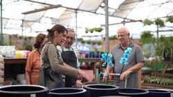Family shop for plants with Salesman at Flower Market Stock Footage