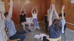 Serene creative business people practicing yoga in circle in office Stock Footage