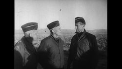 United States, 1952: Generals William Kean, Joseph Swing, and Mark Clark watch as army troops anxiously wait 7 miles away from an atomic bomb detonation Stock Footage