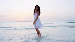 Beautiful Asian Chinese female dancing on tropical beach Stock Footage