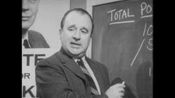 1960s: Man stands at chalkboard, writes numbers on board with chalk, talks Stock Footage