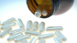 Herbal pills on white table. Pharmatheutical production. Herb capsule in tube Stock Footage