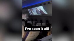 Passenger projects film onto overhead bin on flight Instructional Video