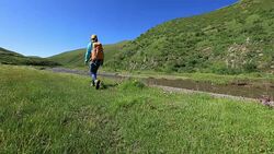 Young woman hiking in high land grassland mountains Stock Footage