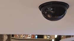 Dome security camera on top of ceiling inside mall Stock Footage