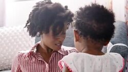 Mother singing song to baby daughter into air and smiling Stock Footage