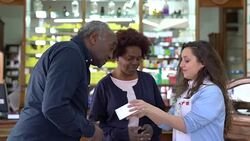 Pharmacist showing medicine to senior couple Stock Footage