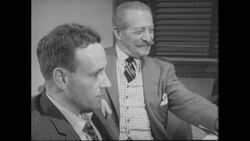 1960s: Group of men sit around, talk, smoke cigarettes Stock Footage