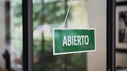 Young man opening a Spanish shop Stock Footage