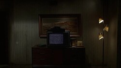 WIDE ANGLE OF TELEVISION SET WITH STATIC ON TOP OF BUREAU IN LOWER CLASS MOTEL ROOM.  DINGY ROOM HAS LAMP AND PAINTING, ICE BUCKET NEXT TO TV. BURN-INS. Stock Footage