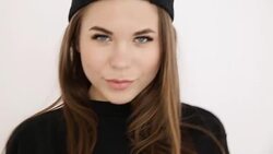 a teenage girl in black hip-hop clothes and a cap dances at the white wall- close-up, handheld shoot, small depth of field Stock Footage