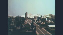 1960s: View of model of small town with public buildings, homes, trees, a main road, and mountains in background Stock Footage