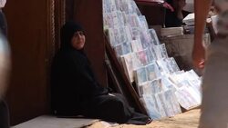Woman sitting on side of road News Clip